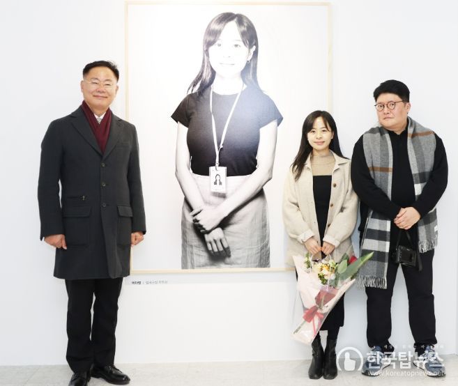 칠곡사람들 사진전 개막식에서 김재욱 칠곡군수가 칠곡군청 이다정 주무관 사진앞에서 기념 촬영을 하고 있다