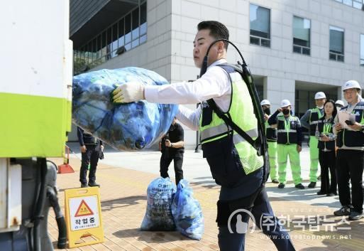오언석 도봉구청장이 ‘입는 로봇’을 입고 쓰레기를 청소차에 옮기고 있다